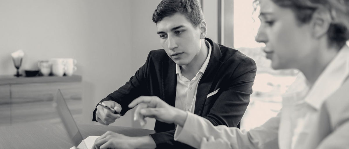 Deux personnes examinent ensemble un écran d'ordinateur portable, lumière du jour.