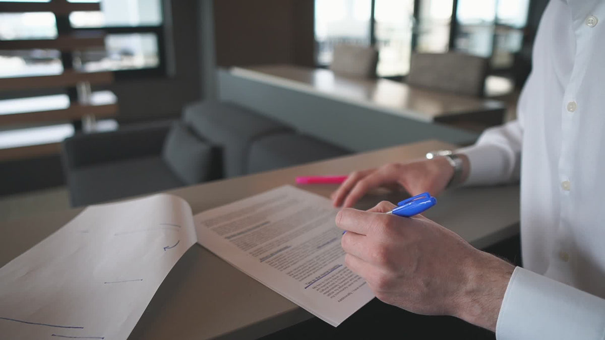 Mains annotant un document sur un bureau, sans visage